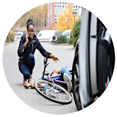 a woman crouches down at the scene of a bicycle accident